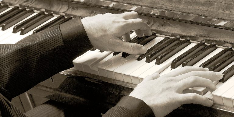 Two hands playing over a piano keyboard