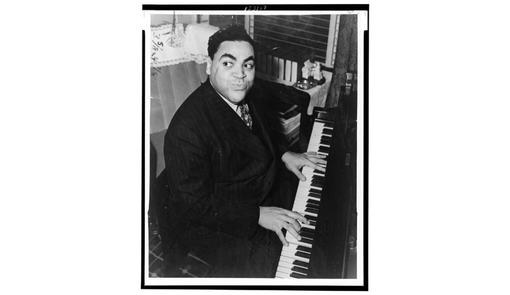 Fats Waller, three-quarter length portrait, seated at piano, facing front